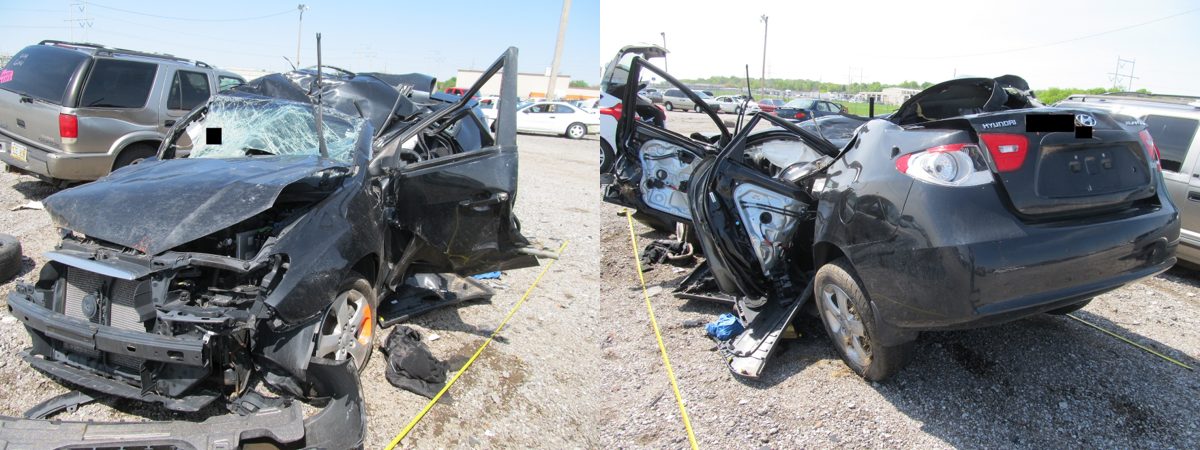 A black sedan with significant roof deformation after a rollover crash.